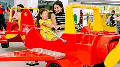 A child and parent on the City Airport plane ride at LEGOLAND Dubai